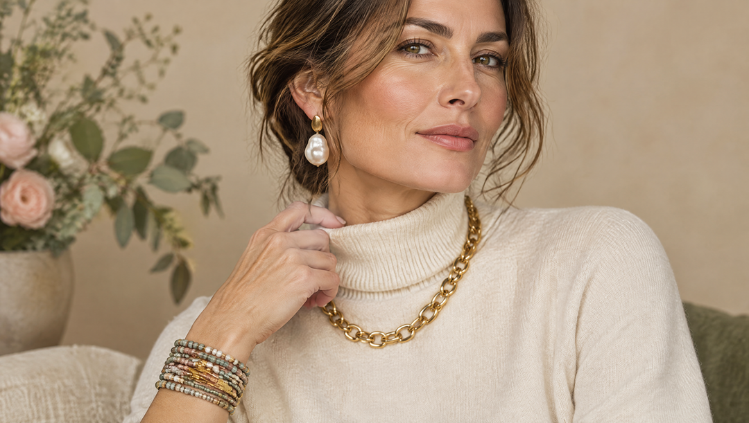Femme portant une chaîne dorée épaisse, une perle baroque et un bracelet multi-rangs, tendances bijoux 2026-2027