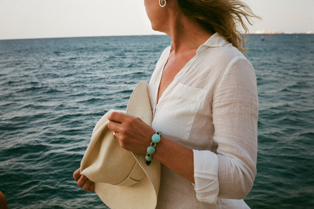 Femme au bord de la mer portant un bracelet turquoise